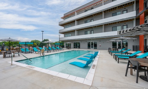 Outdoor swiming pool with blue patio furniture